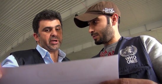 Two WHO staff looking at a document and discussing.